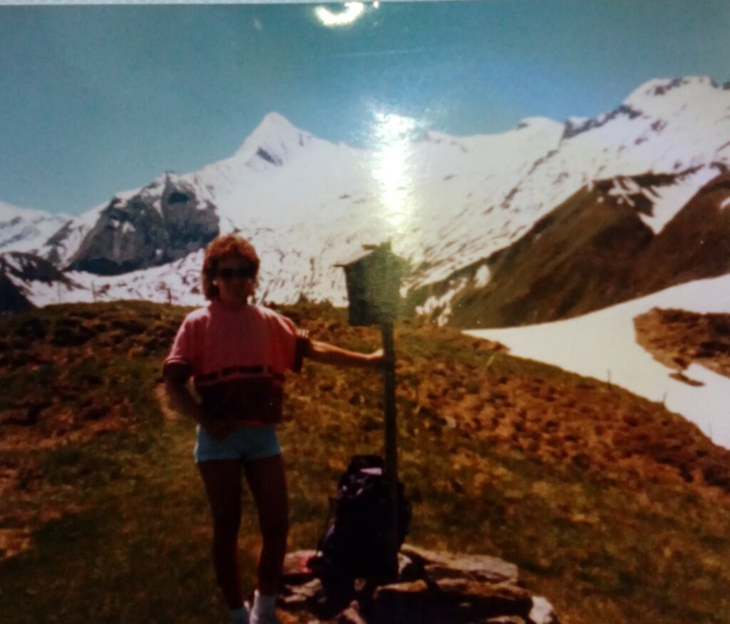 Eine Frau steht vor dem Kitzsteinhorn in 1990. Auf dem Berg liegt im Sommer viel Schnee.