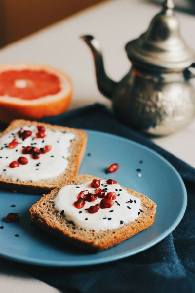 2 Toast mit Frischkäse und Schwarzkümmel auf einem blauen Teller