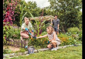 Gardena Garten- und Pflegehandschuhe trägt eine Familie bei der Gartenarbeit