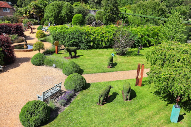 Ein großer Garten mit Formschnitt Figuren und zwei Holunder daneben als Kontrastprogramm.